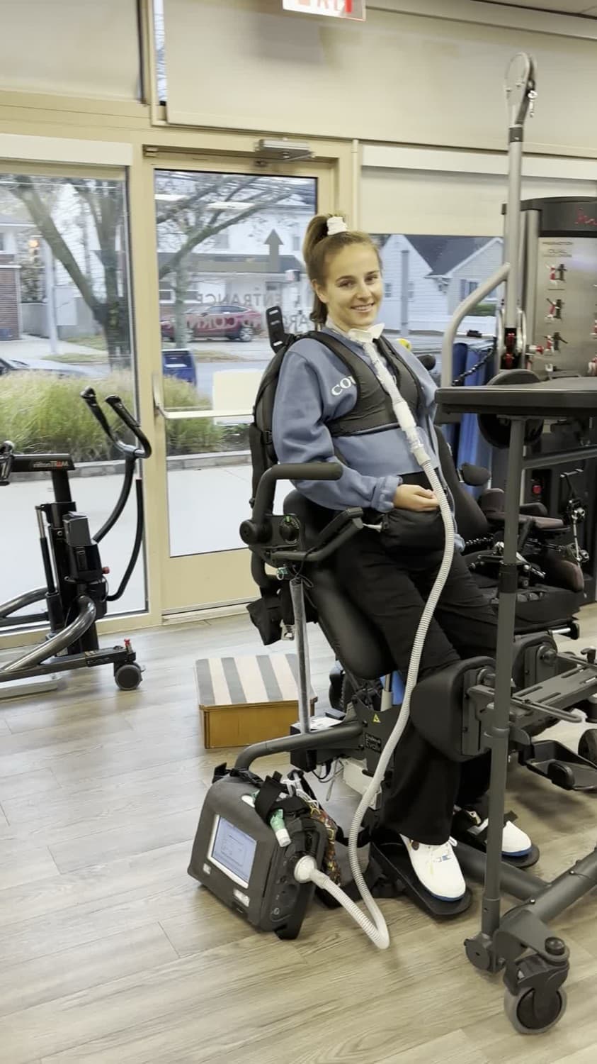 Rebecca smiling, standing upright during rehab.